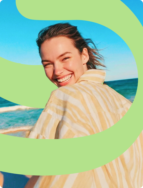 A smiling woman at the beach framed by green Supzential brand waves, illustrating health and vitality.