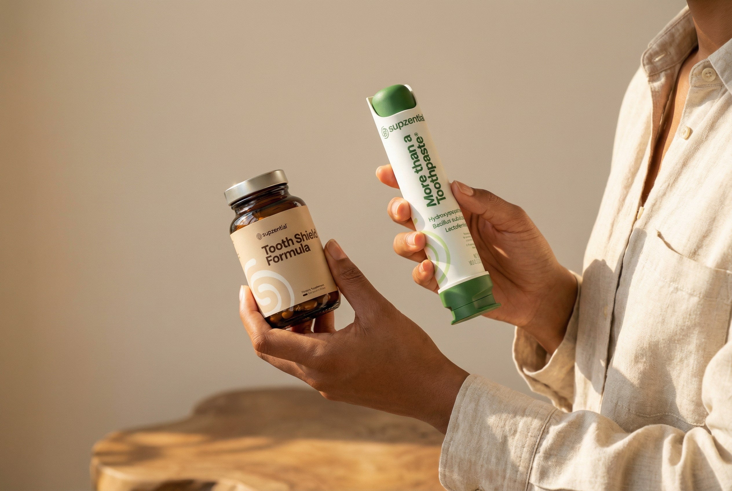 A person holds both Supzential More than a Toothpaste and Tooth Shield Formula, showcasing the brand’s complete inside-out oral care system.